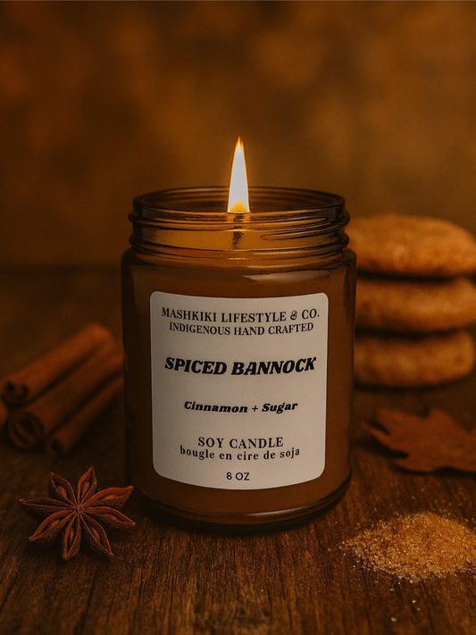 Spiced Bannock candle in a jar with cinnamon sticks and cookies on a wooden surface